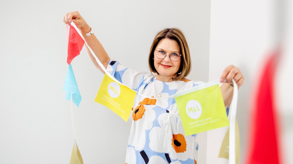 MLL:n pääsihteeri Milla Kalliomaa kannattelee värikästä lippunauhaa